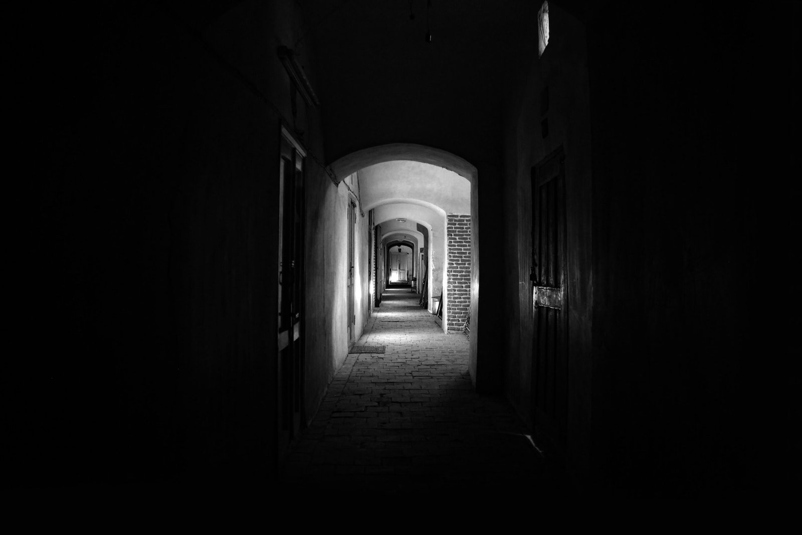 a dark hallway with a light at the end